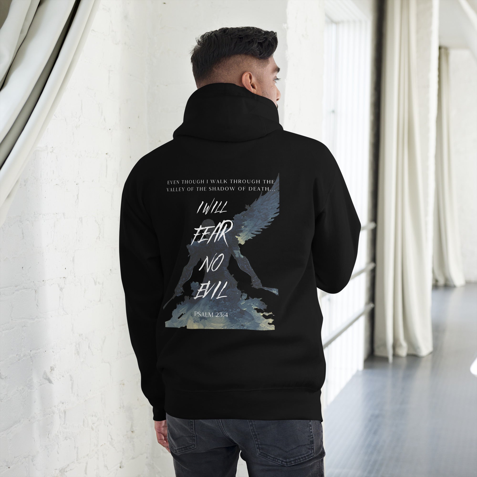 Man leaning against the wall wearing a black hoodie.